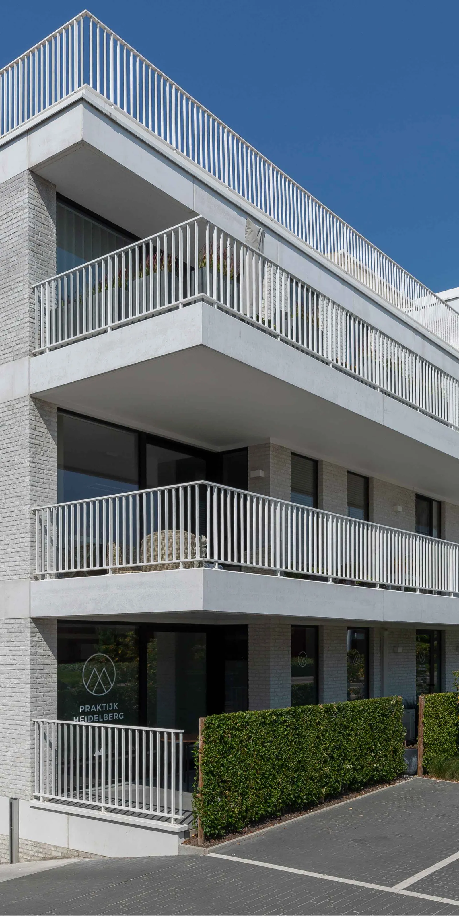 Witte gevel met aluminium balustrades van Difralu op elke verdieping